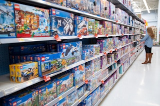 A woman looking at LEGO in the toy aisle at Walmart.