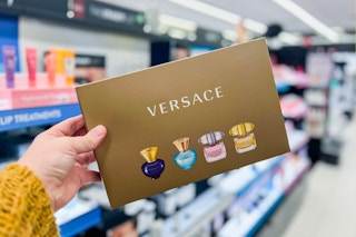 a hand holding up a box of versace mini fragrances in a sephora aisle at kohl's