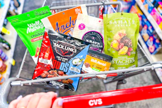 person pushing a cart with a variety of snack foods in it