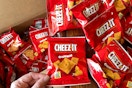 a hand grabbing a bag of snack-sized Cheez-its from a box