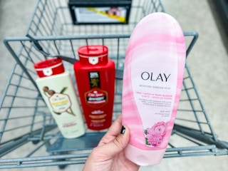 hand holding body wash near shopping cart