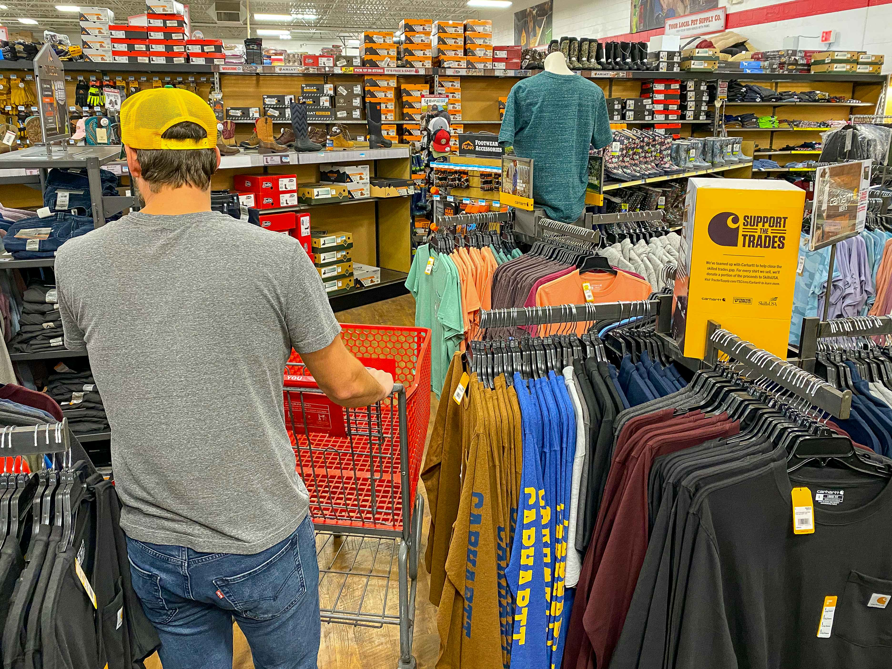 A man shopping in the men's apparel section of Tractor Supply.