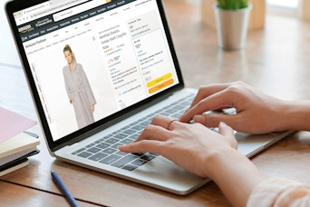 person on laptop shopping for barefoot dreams robe on amazon outlet