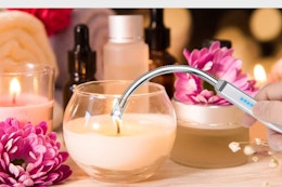 someone using an electric lighter on a candle