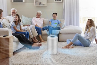 A family sits in a living room that is being purified by one HEPA air filter.