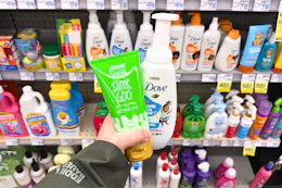 person holding raw sugar and dove body washes in front of the shelf