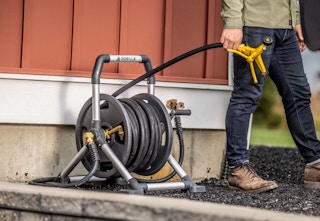 person pulling a hose off a hose reel