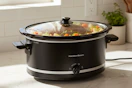 lifestyle image of a hamilton beach slow cooker on a kitchen counter with food cooking in it