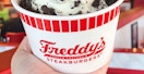 a person holding ice cream from freddys