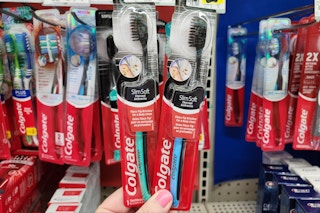 hand holding colgate charcoal manual toothbrushes at dollar general