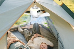 a man and woman under a camping fan