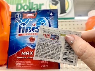 coupon being held in front of finish max dishwashing pods