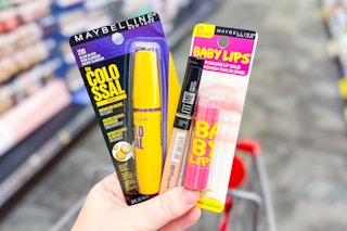 hand holding maybelline baby lips lip balm and colossal mascara in cvs