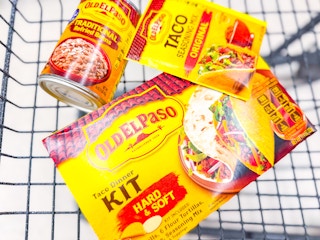 old el paso taco kit, seasoning, and refried beans in a cart
