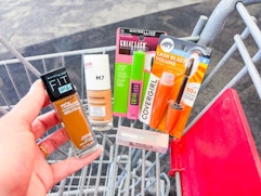 hand holding maybelline foundation with covergirl products cvs