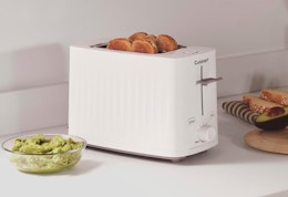 a beige toaster on a counter with toast in it