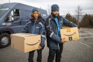 two amazon delivery drivers holding packages