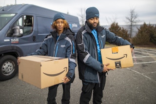 two amazon delivery drivers holding packages