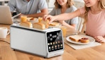 a toaster with toast inside on a wooden table with a family