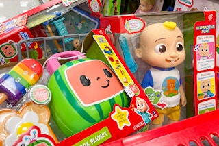 Cocomelon toys in the basket of a Target shopping cart.