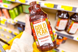 hand holding a bottle of gold peak tea