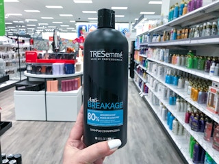 hand holding a bottle of tresemme shampoo at target
