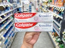hand holding colgate toothpaste in walgreens