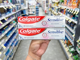 hand holding colgate toothpaste in walgreens