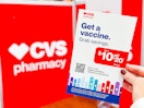 hand holding a vaccine coupon in front of a cvs