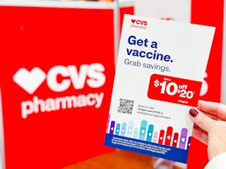hand holding a vaccine coupon in front of a cvs