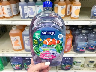 hand holding bottle of Softsoap refill in front of store shelf