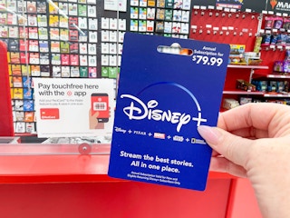 person holding disney plus gift card in target