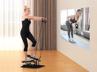 a woman using a mini stepper in a room