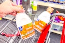 person putting similac ready to feed baby formula in a cart