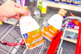 person putting similac ready to feed baby formula in a cart