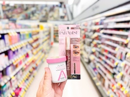 hand holding loreal lash paradise mascara and almay micellar rounds in walgreens