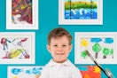 kid standing in front of framed paintings