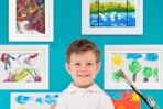 kid standing in front of framed paintings