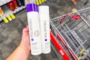 person holding paul mitchell shampoo and conditioner over a cvs cart