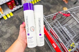 person holding paul mitchell shampoo and conditioner over a cvs cart
