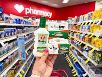 person holding bactine products in an aisle