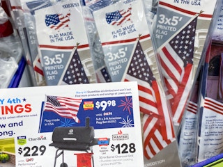 Lowe's July 4th Savings flyer held in front of Valley Forge American Flags. The savings flyer advertises these flags as $9.98, ...