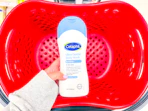 hand holding a cetaphil body wash over a target basket