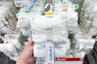 hand holding a pack of carter's bodysuits at target