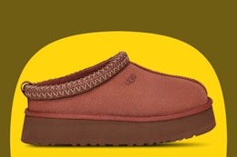 Ugg women’s slippers on a yellow and olive background. 