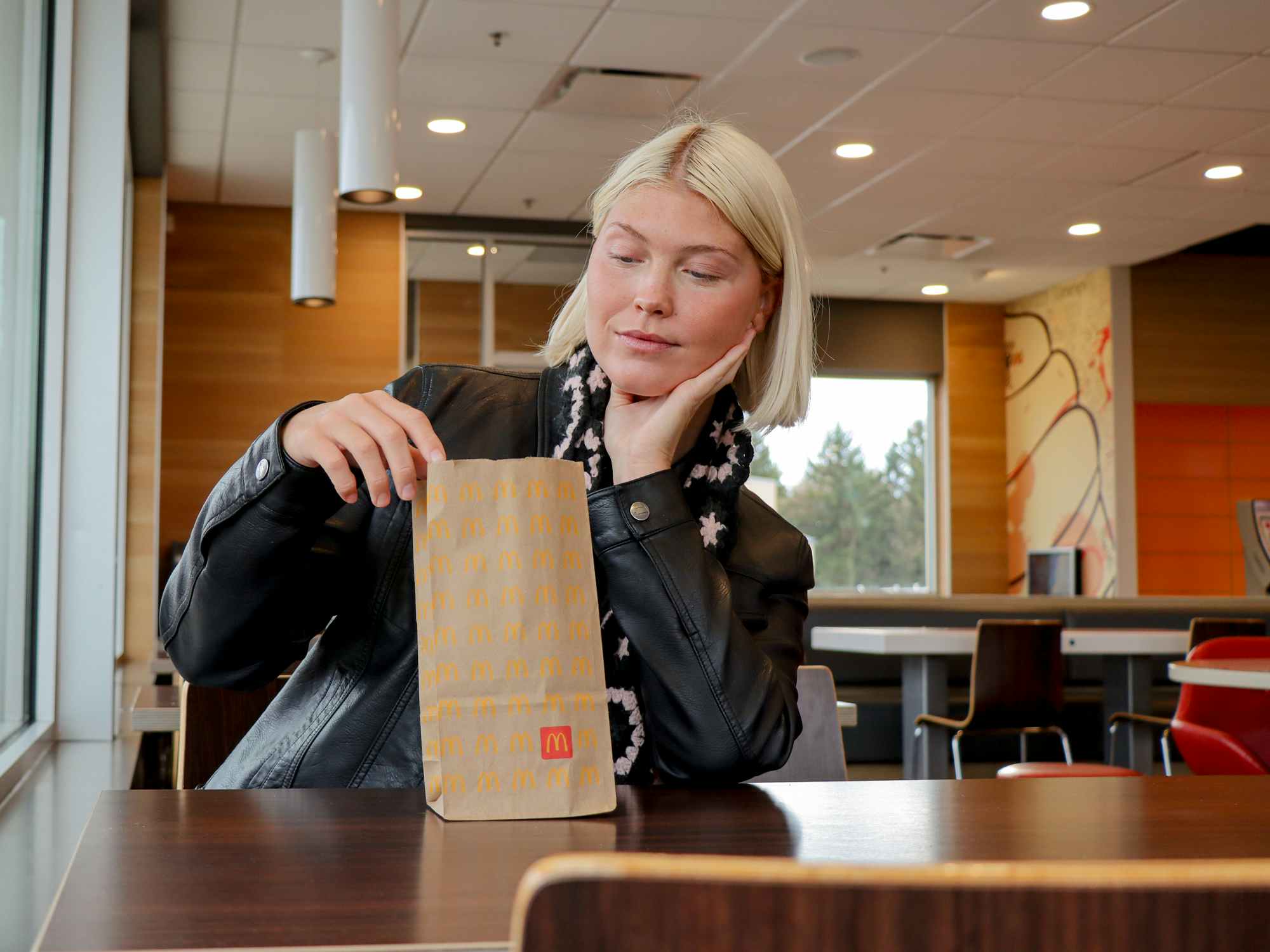 a person sitting with a mcdonalds bag