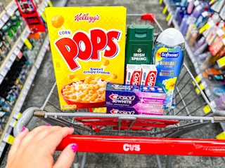 person pushing a cart with cereal, toothpaste, and body wash in it