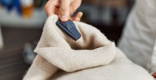 Someone looking at a security tag that is on a sweater