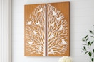 Lifestyle image of Home Decorators wooden wall art panels featuring tree branches and birds (hanging on wall)