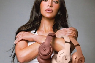 Kim Kardashian holding three neutral-toned Beats headphones